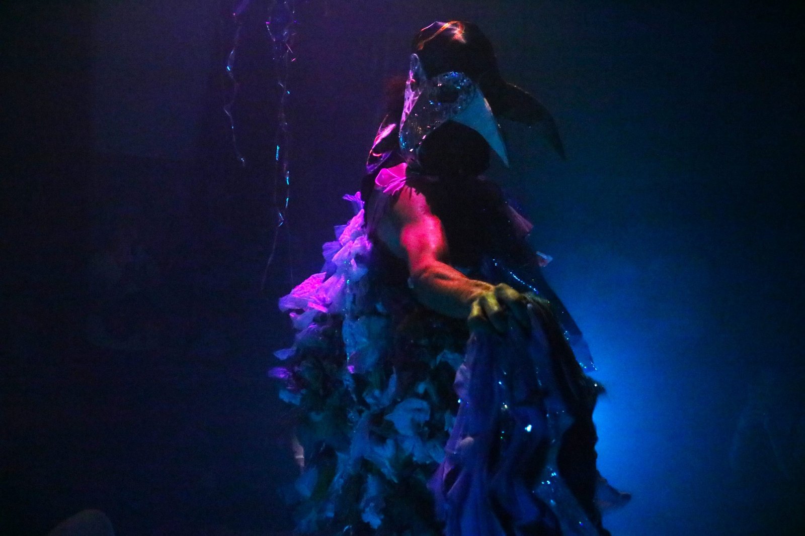 Foto colorida com luz azul mostrando um estudante da SP Escola de Teatro em experimento cênico