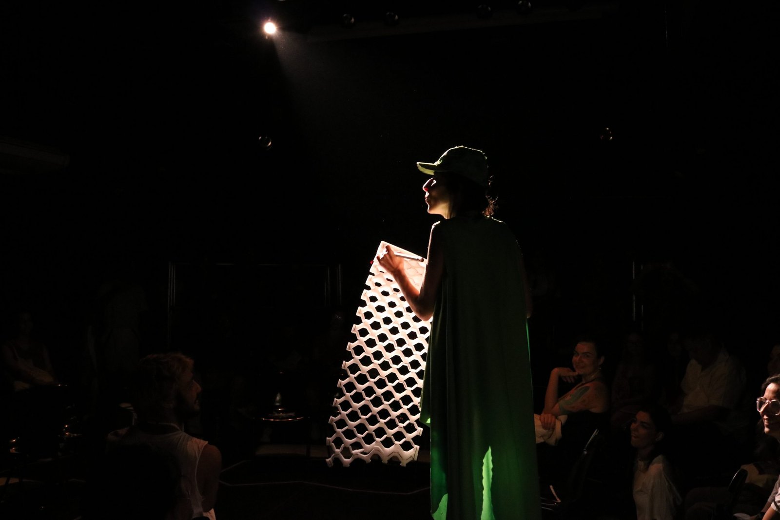 Foto colorida com luz escura mostrando um estudante da SP Escola de Teatro em experimento cênico