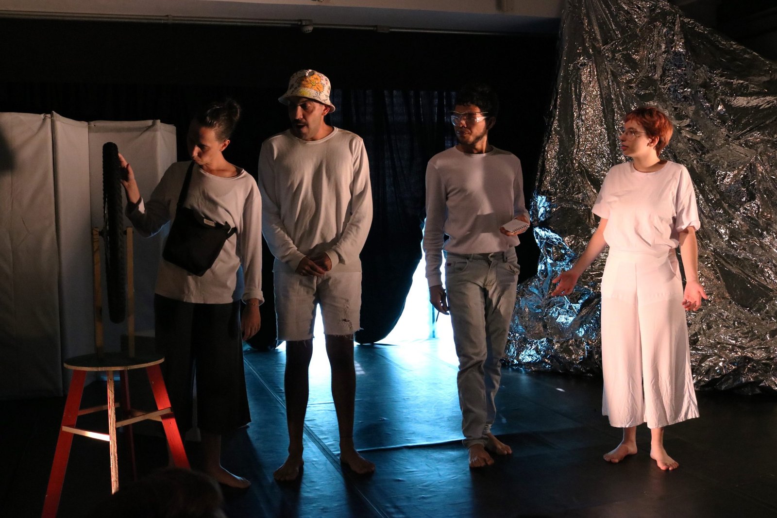 Foto colorida mostrando quatro estudantes da SP Escola de Teatro em experimento cênico