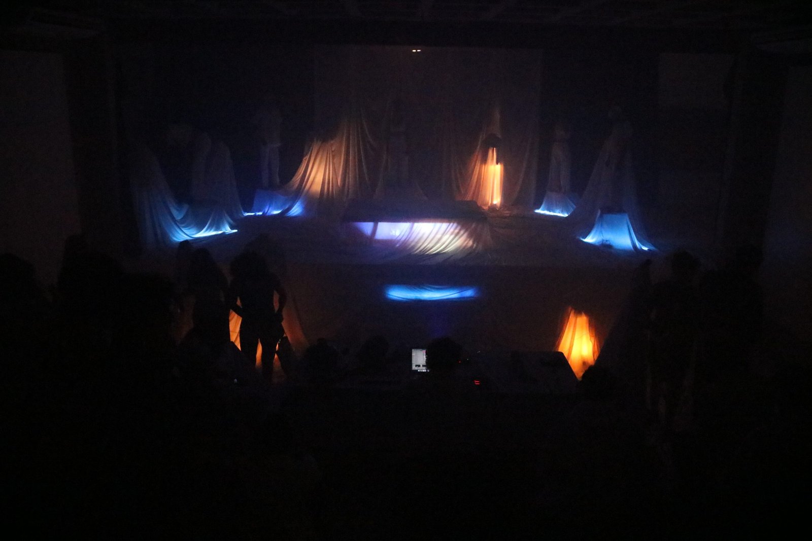 Foto com luz escura mostrando cena do experimento cênico da SP Escola de Teatro