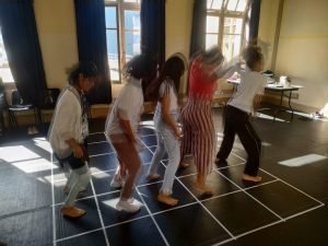 Estudantes Ana Leticia e Juliana conduzem oficina com as crianças bolivianas em uma das salas da sede Brás da SP Escola de Teatro