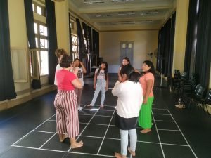 Em uma roda as estudantes Alicia e Juliana conduzem oficina para as crianças bolivianas em uma das salas da sede Brás da SP Escola de Teatro