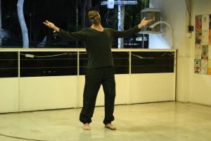 Fotografia colorida mostrando Miguel Rosa com uma máscara em aula-espetáculo no lançamento do livro