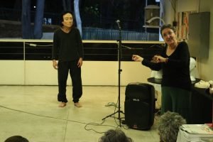 Fotografia colorida mostrando Tiche Vianna apresentando uma aula-espetáculo ao lado de Miguel Rosa no lançamento do livro