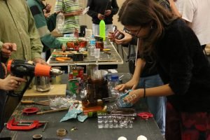 Fotografia colorida mostra estudantes criando instrumentos em aula com Barulho Max