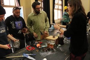 Fotografia colorida mostra estudantes criando instrumentos em aula com Barulho Max