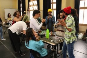 Fotografia colorida mostra estudantes criando instrumentos em aula com Barulho Max