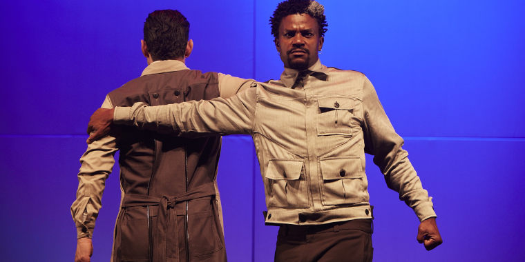 Cena da peça "12 anos ou A Memória da Queda", colorida, com dois homens em cena atuando