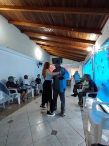 Fotografia colorida dos estudantes da SP Escola de Teatro na atividade de contrapartida no Centro de Acolhida Especial para Idosos do Brás