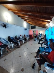 Fotografia colorida dos estudantes da SP Escola de Teatro na atividade de contrapartida no Centro de Acolhida Especial para Idosos do Brás