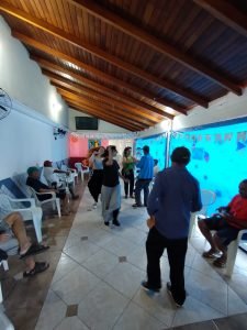 Fotografia colorida dos estudantes da SP Escola de Teatro na atividade de contrapartida no Centro de Acolhida Especial para Idosos do Brás