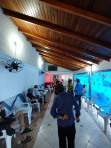 Fotografia colorida dos estudantes da SP Escola de Teatro na atividade de contrapartida no Centro de Acolhida Especial para Idosos do Brás