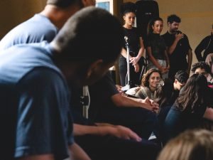 Fotografia de grupo de jovens da Fundação CASA assistindo experimento cênico
