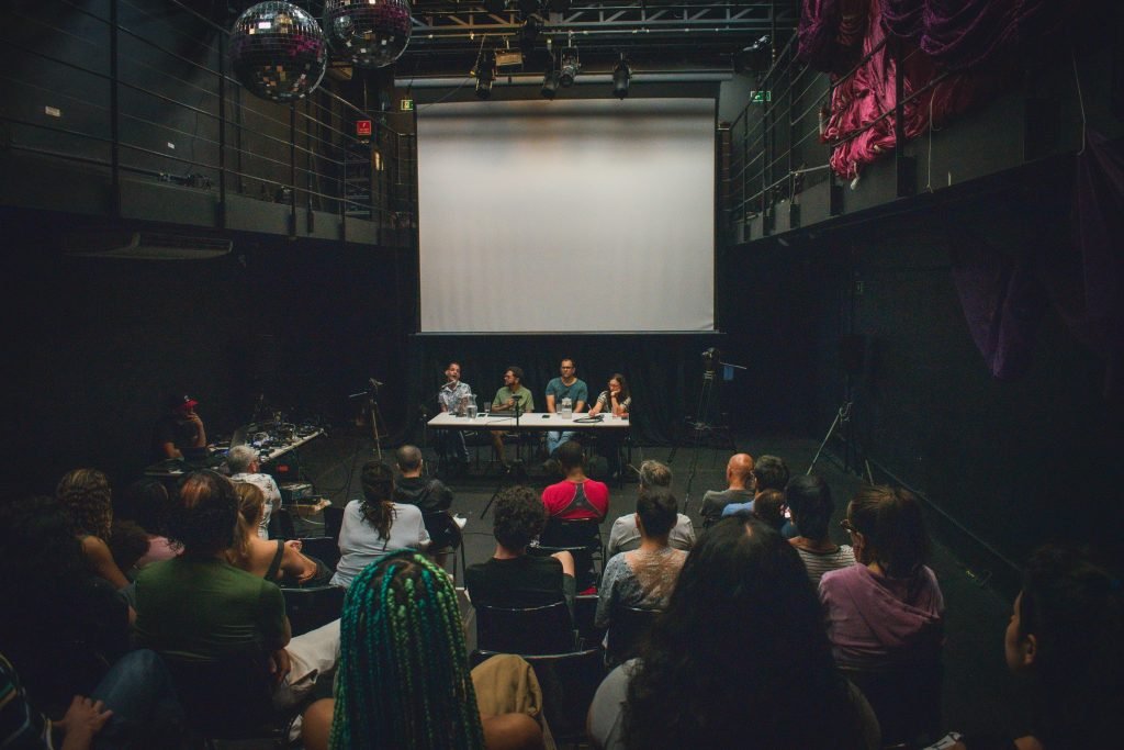Fotografia colorida de palestra "Desafios da Acessibilidade na Indústria Criativa" com Elder Fraga, Fernanda Amaral, Herberth Vital e Marcos Abranches na Roosevelt