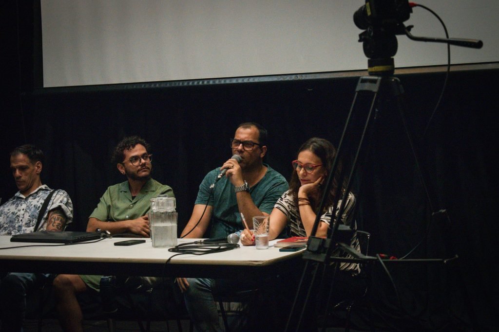 Fotografia colorida de palestra "Desafios da Acessibilidade na Indústria Criativa" com Elder Fraga, Fernanda Amaral, Herberth Vital e Marcos Abranches na Roosevelt
